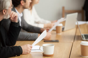Attentive Senior Businessman Holding Documents Focused On Listen